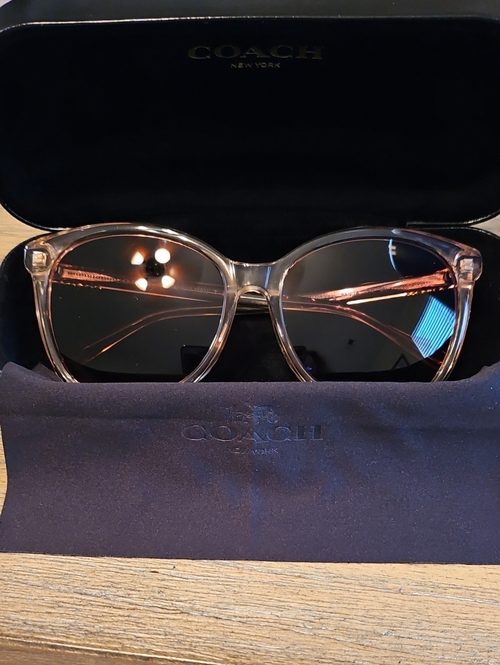Coach Women's Transparent Pink Frame Sunglasses with Dark Lenses.